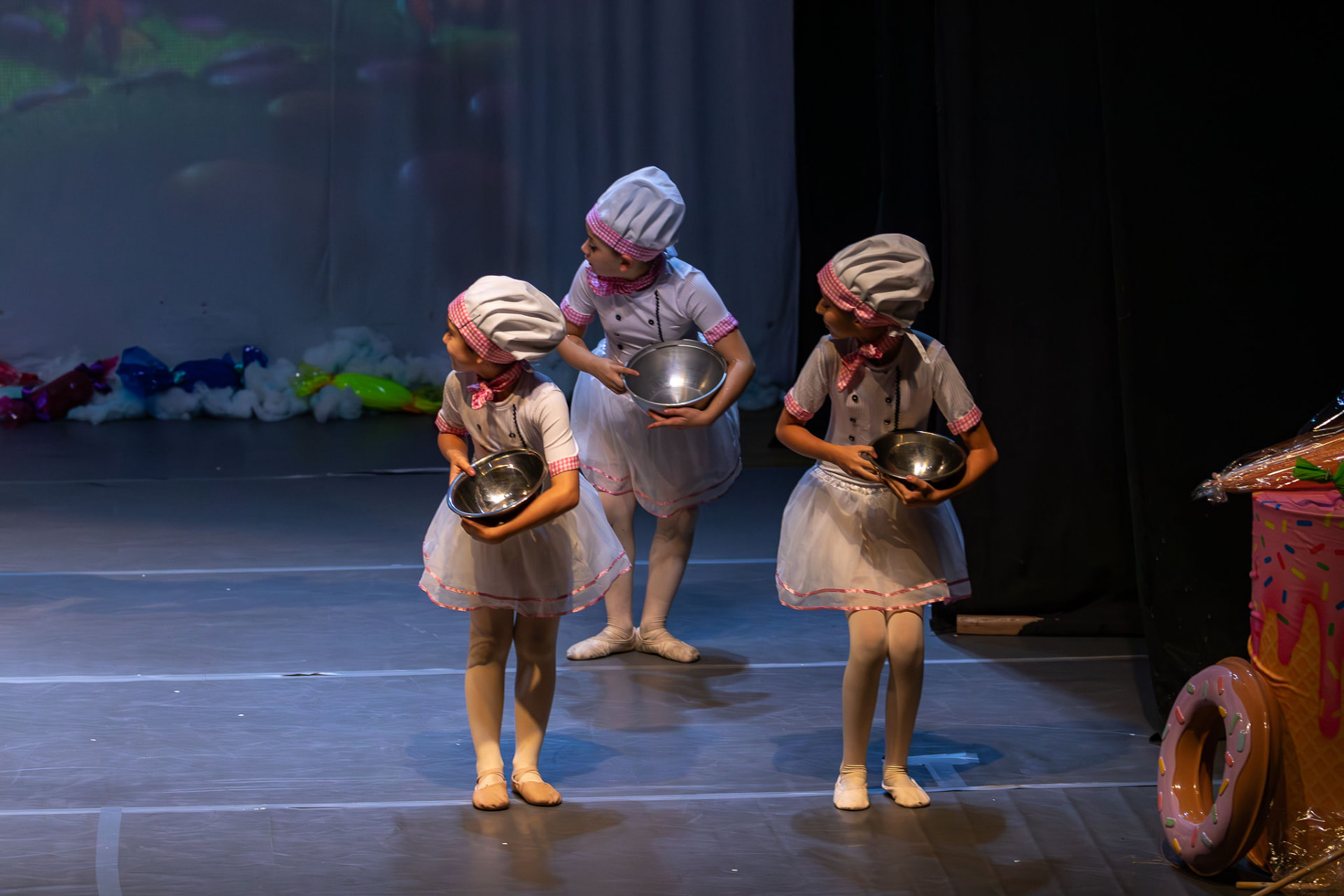 Alunas caracterizadas como confeiteiras em apresentação infantil